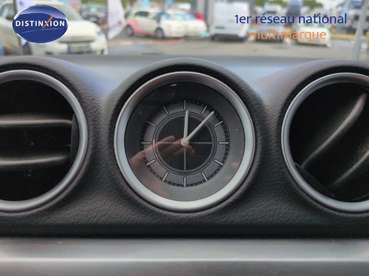 Gros plan sur l'horloge centrale du tableau de bord du Suzuki Vitara 1.4 Boosterjet Hybrid gris métallisé.
