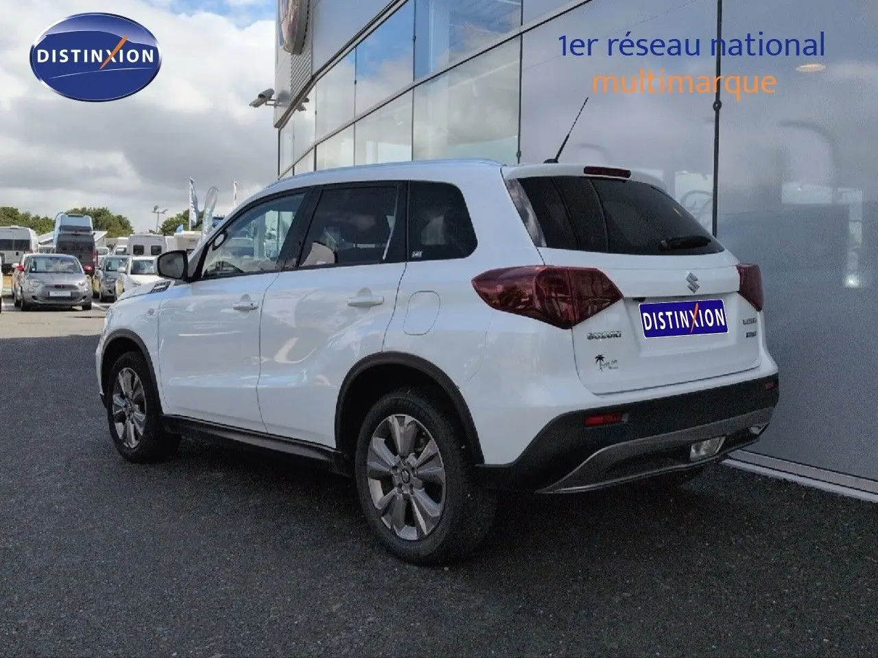 Suzuki Vitara blanc vue 3/4 arrière droit, avec vitres arrière surteintées et jantes alliage.