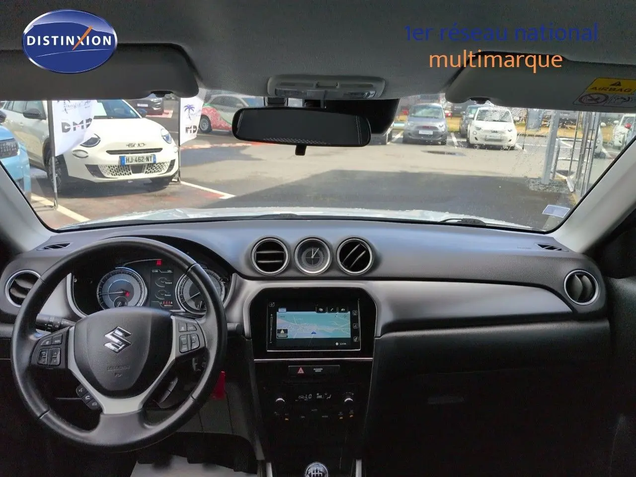 Vue intérieure avant du Suzuki Vitara 1.4 Boosterjet Hybrid 2021, tableau de bord noir avec écran tactile et volant multifonction.