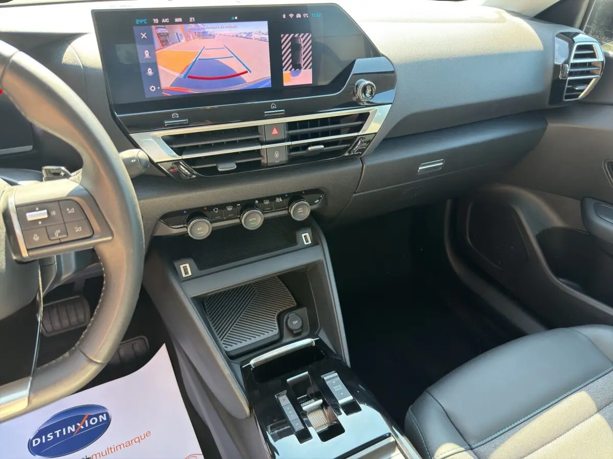 Vue intérieure côté conducteur du tableau de bord noir du Citroën C4 2023 avec écran tactile et volant cuir multifonctions.