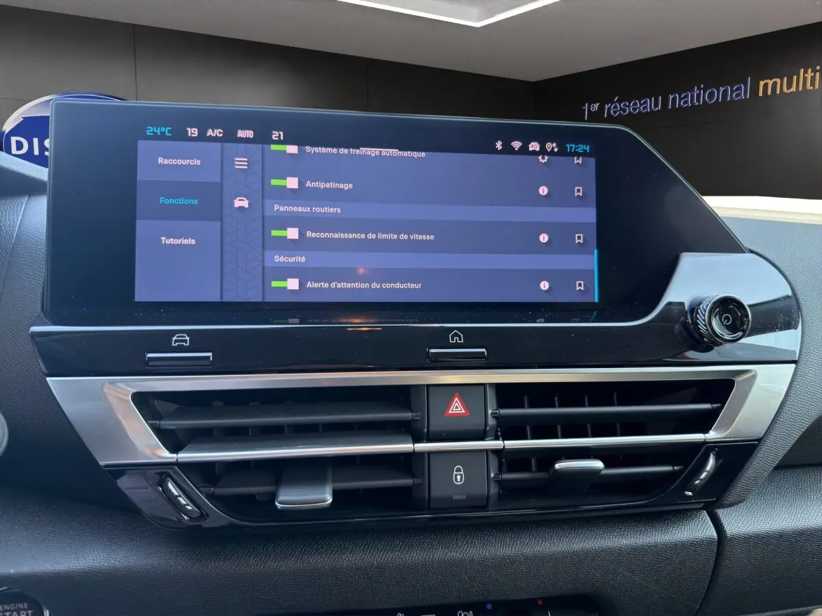 Vue rapprochée de l’écran tactile central et des commandes de climatisation du tableau de bord du Citroën C4 gris foncé 2023.