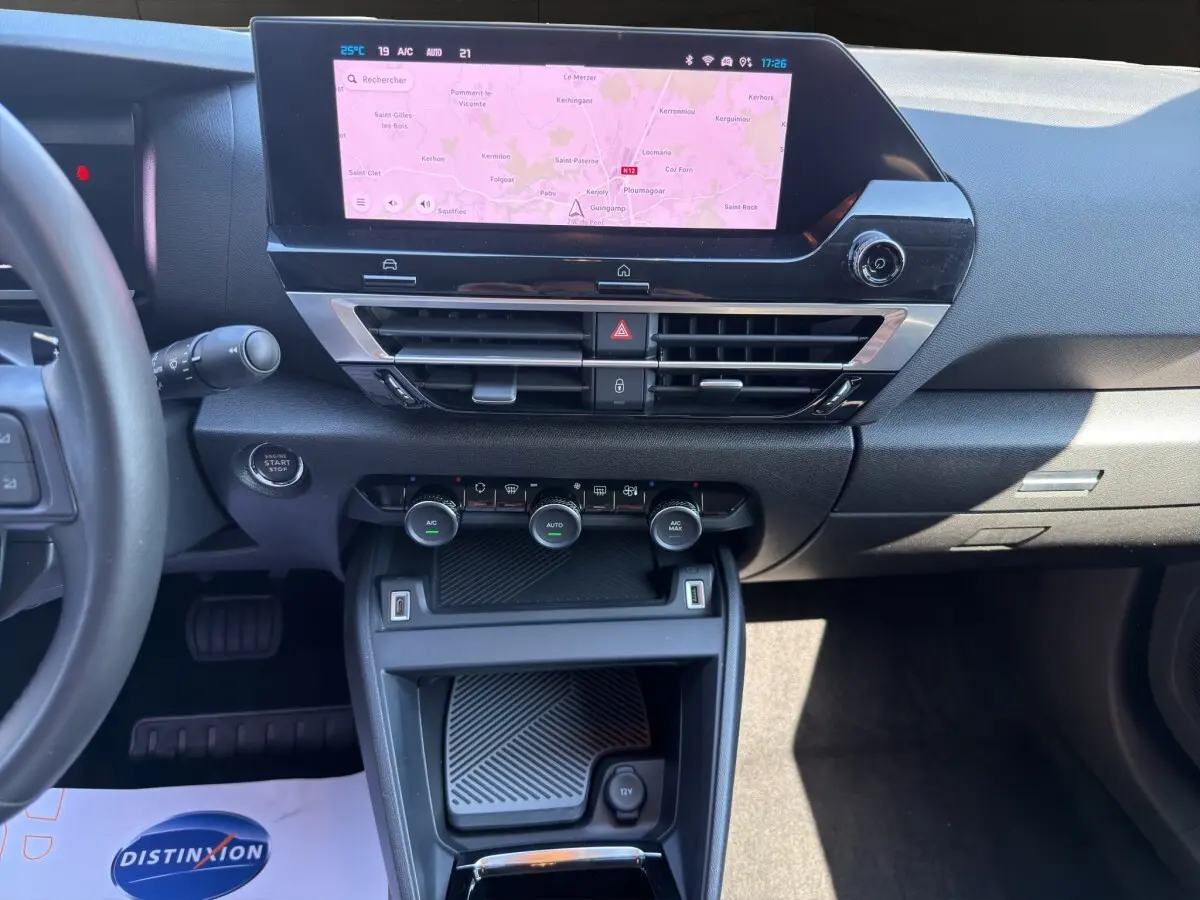 Vue intérieure centrée sur la console centrale et l'écran tactile de navigation du Citroën C4 2023 gris foncé.