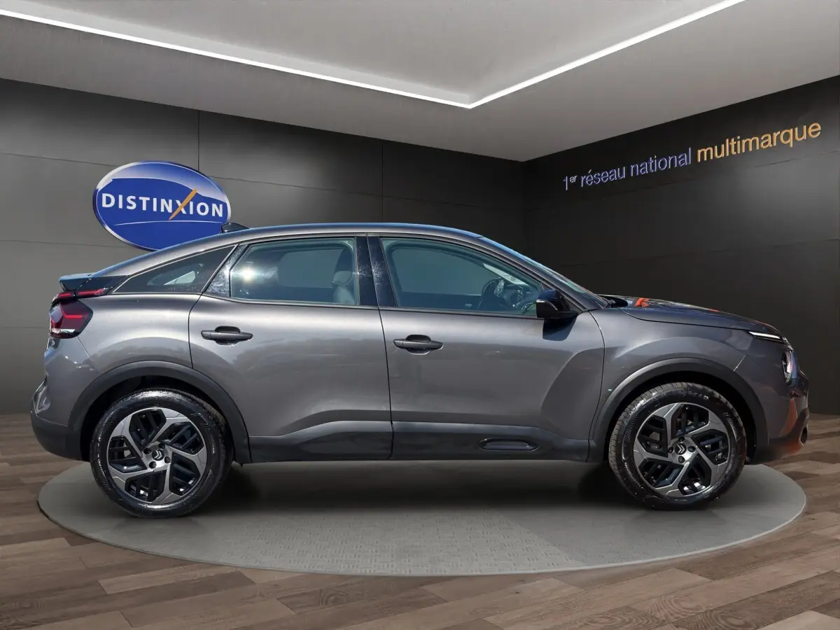 Profil droit de la Citroën C4 2023 gris foncé, avec jantes alliage et toit plongeant distinctif.