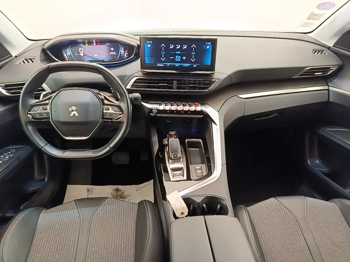 Vue intérieure avant du Peugeot 3008 noir 2022, volant cuir multifonctions et écran tactile central lumineux.