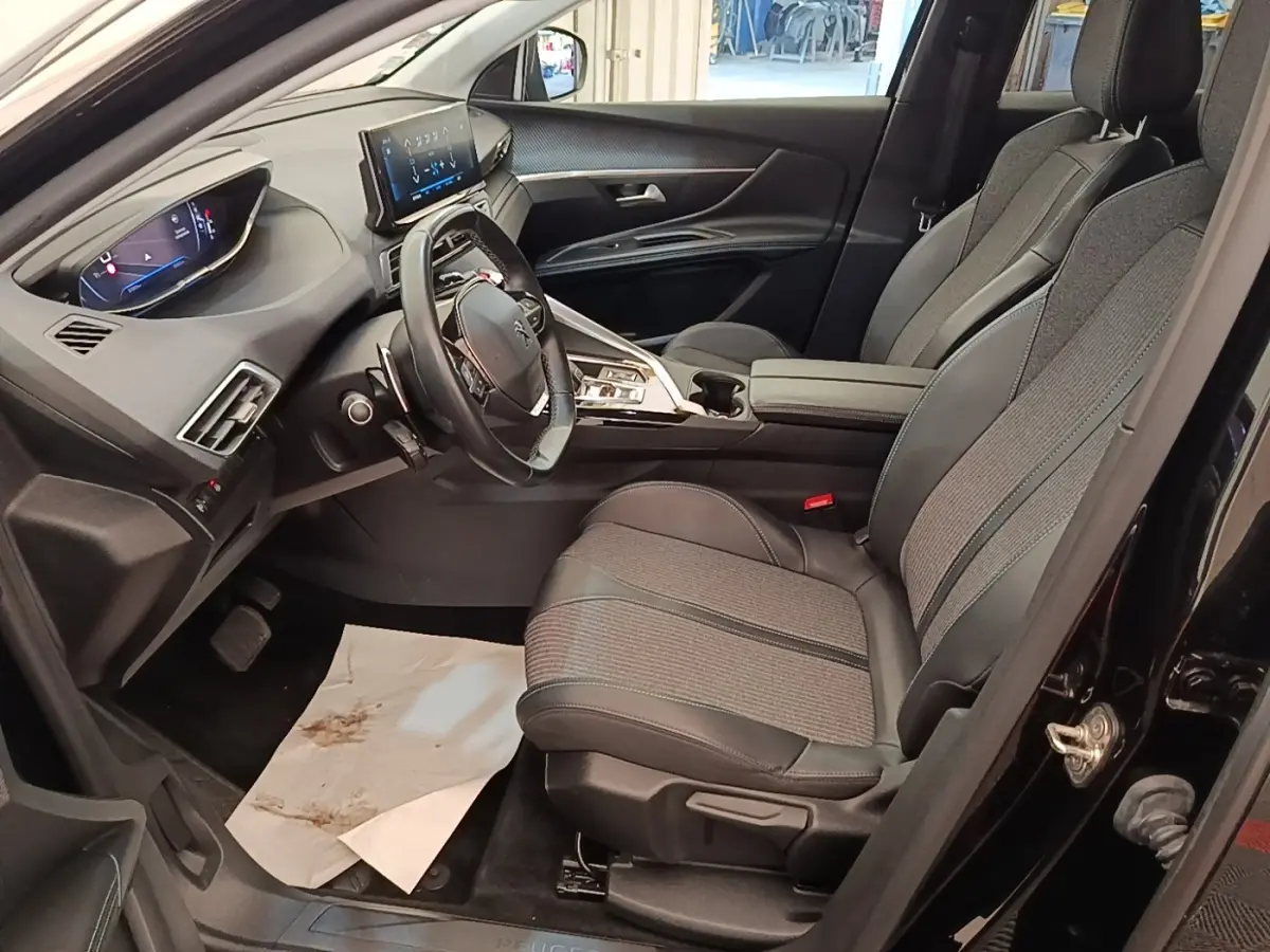 Vue intérieure côté conducteur du Peugeot 3008 noir, mettant en valeur le volant cuir multifonctions et l'écran tactile central.