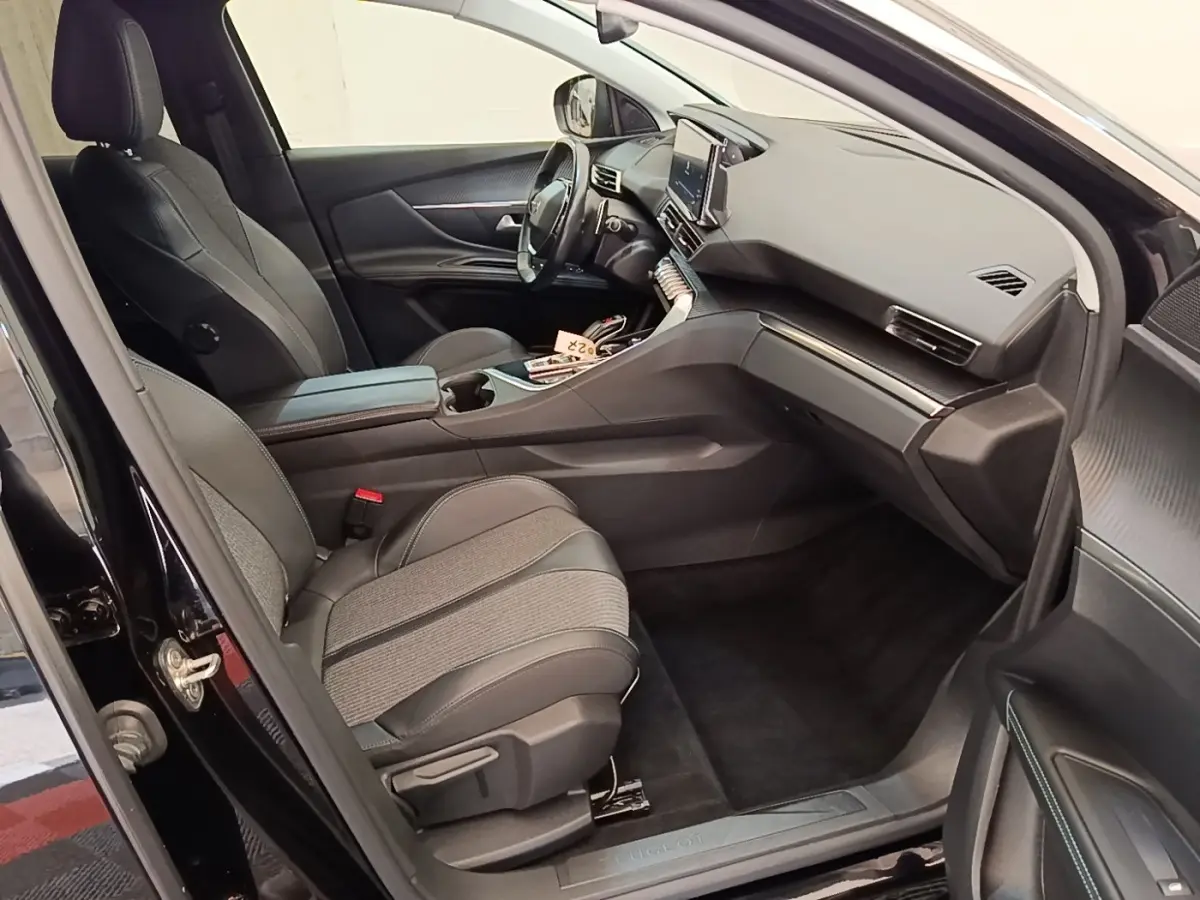 Intérieur noir du Peugeot 3008 PureTech 130, vue côté passager avant avec sièges cuir et tableau de bord moderne.
