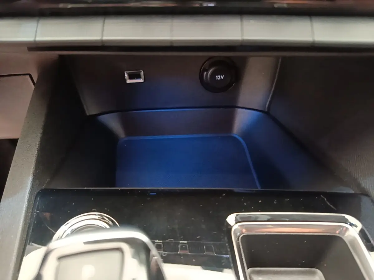 Gros plan sur la console centrale noire du Peugeot 3008 avec prise 12V et port USB visible.