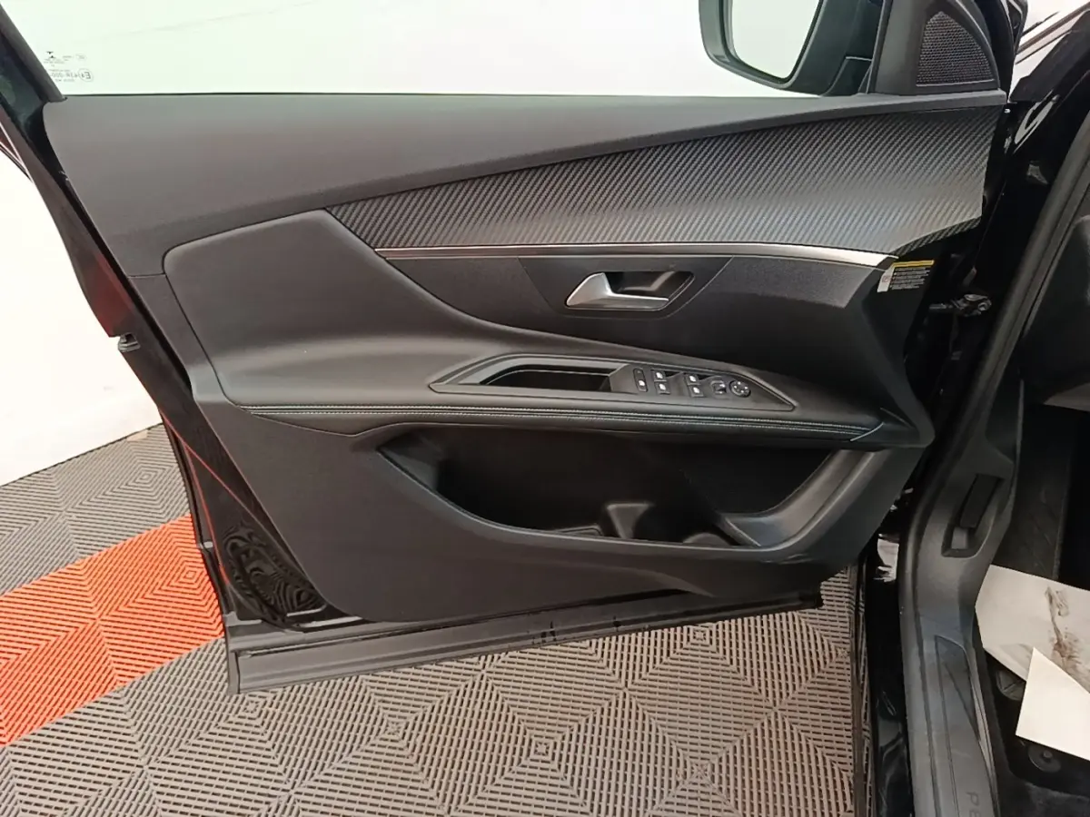 Intérieur porte avant gauche noire du Peugeot 3008 2022 avec commandes vitres et insert carbone.