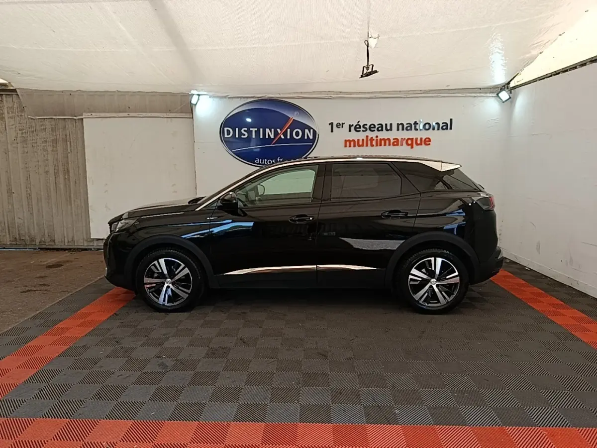 Profil côté gauche d’un Peugeot 3008 noir 2022 dans un garage avec sol gris et bandes rouges.