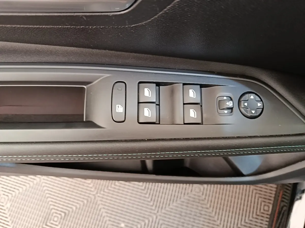 Gros plan sur la commande des vitres électriques côté conducteur du Peugeot 3008 noir, avec surpiqûres blanches sur la garniture.