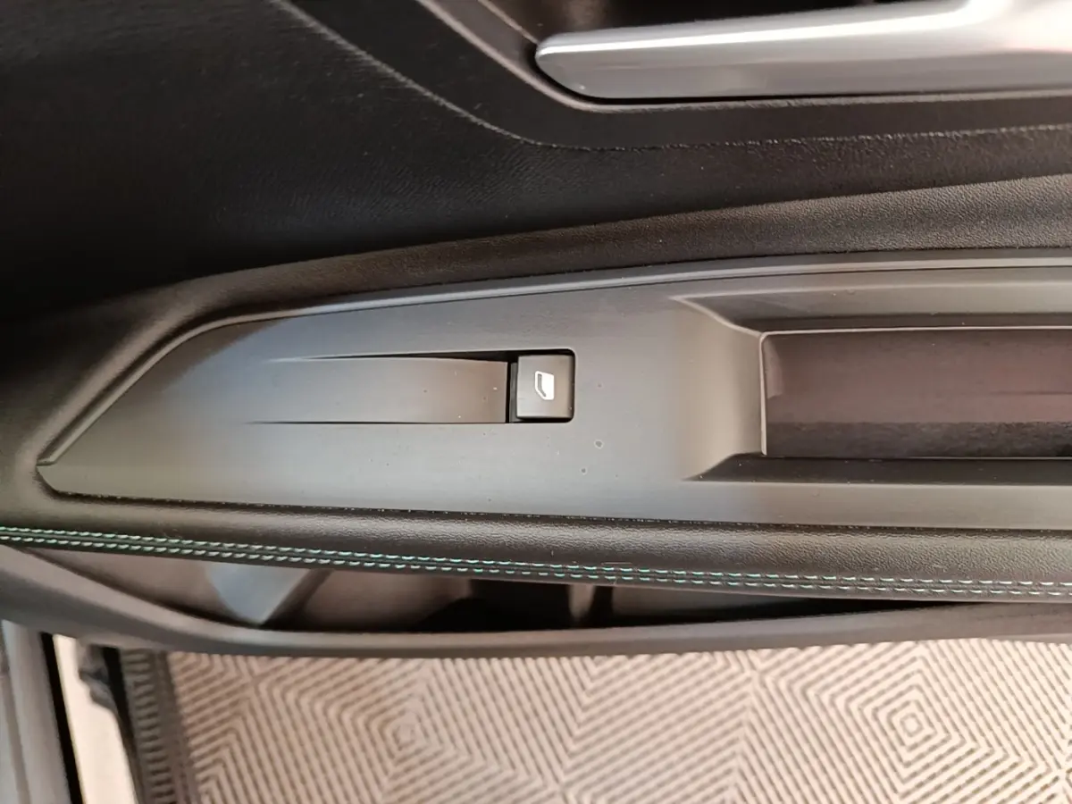 Détail de la commande de lève-vitre sur la porte intérieure côté conducteur d’un Peugeot 3008 noir 2022.