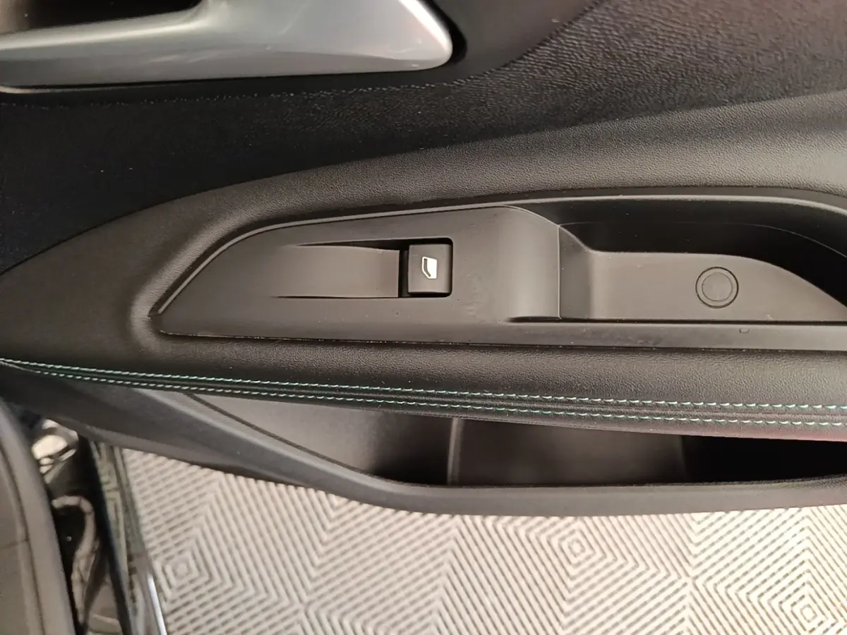 Gros plan sur la poignée intérieure et le bouton de lève-vitre côté conducteur du Peugeot 3008 noir 2022.