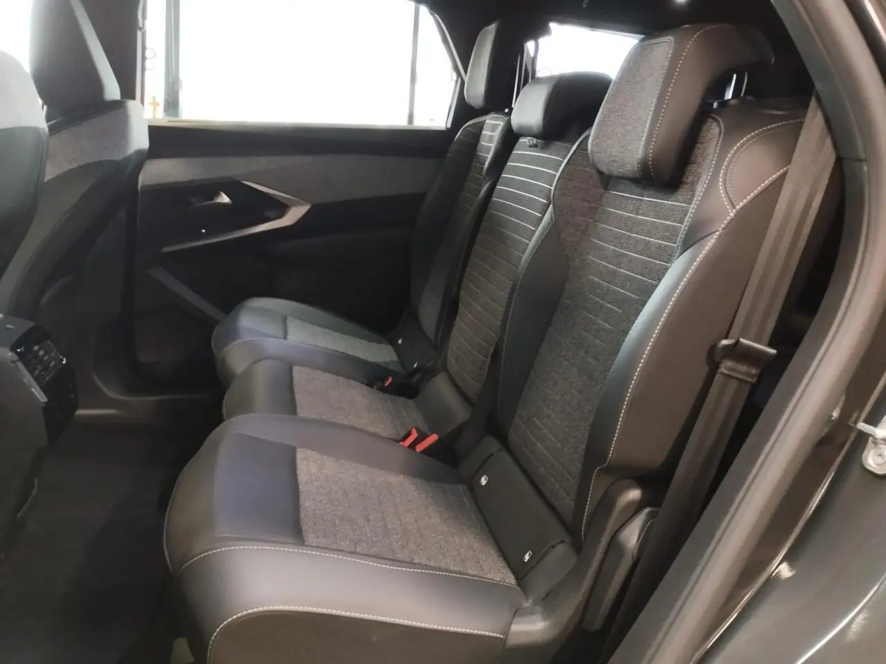 Vue latérale intérieure montrant les sièges arrière gris tissu et cuir du Peugeot 5008 2025 finition Allure.