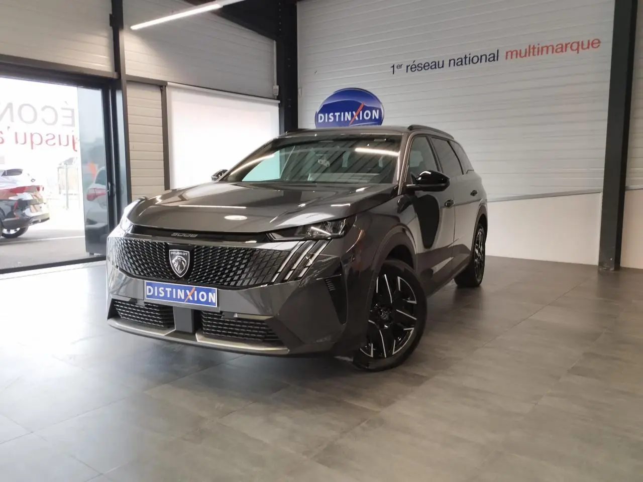 Peugeot 5008 gris titanium en 3/4 avant droit, avec calandre noire et jantes alliage noires diamantées.