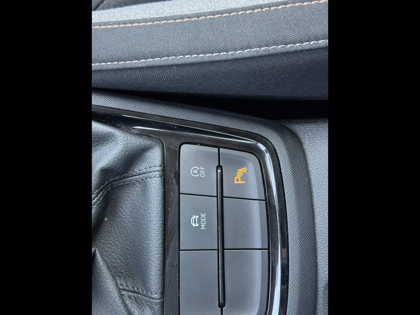 Gros plan sur les boutons de commande du frein de stationnement et mode conduite du Skoda Kamiq 2025, intérieur noir.
