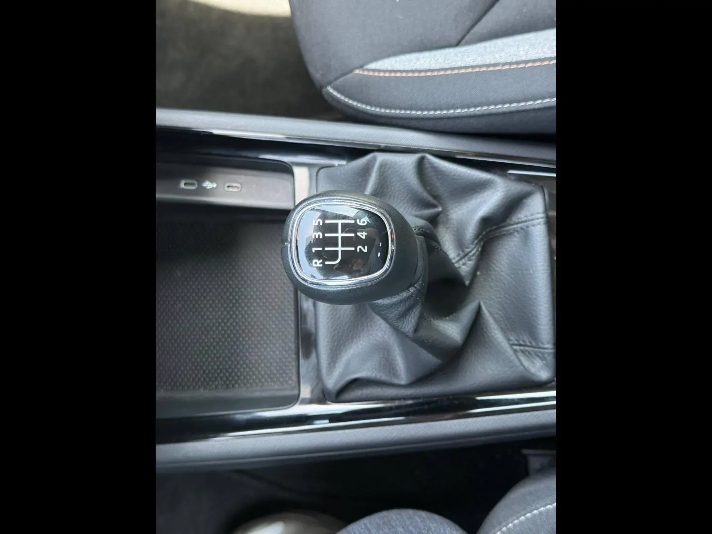 Gros plan sur le levier de vitesses manuel noir du Skoda Kamiq 2025, avec coutures apparentes sur la soufflet en cuir.