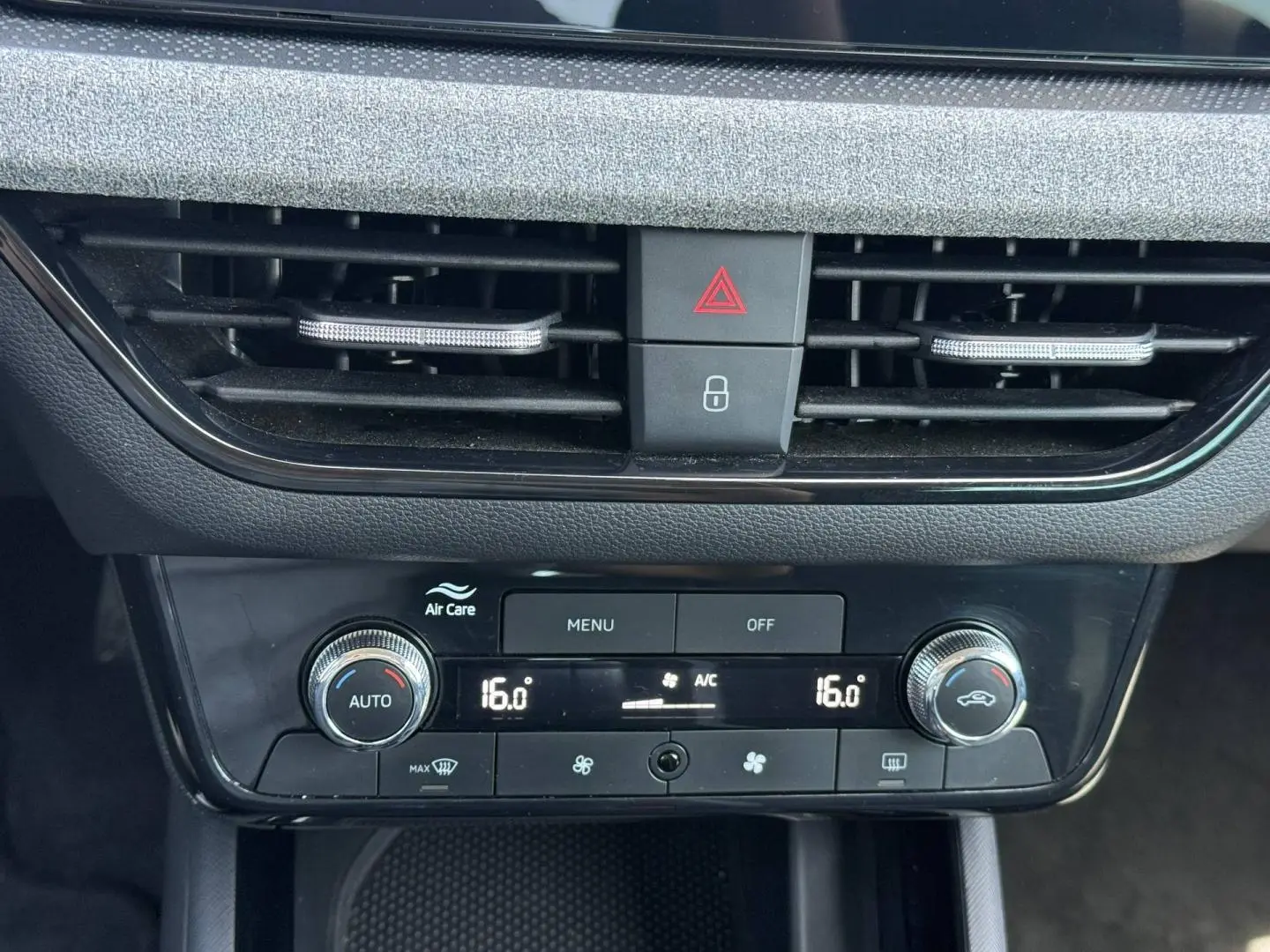 Détail du tableau de bord du Skoda Kamiq 2025, montrant la console de climatisation avec réglages numériques à 16°C.