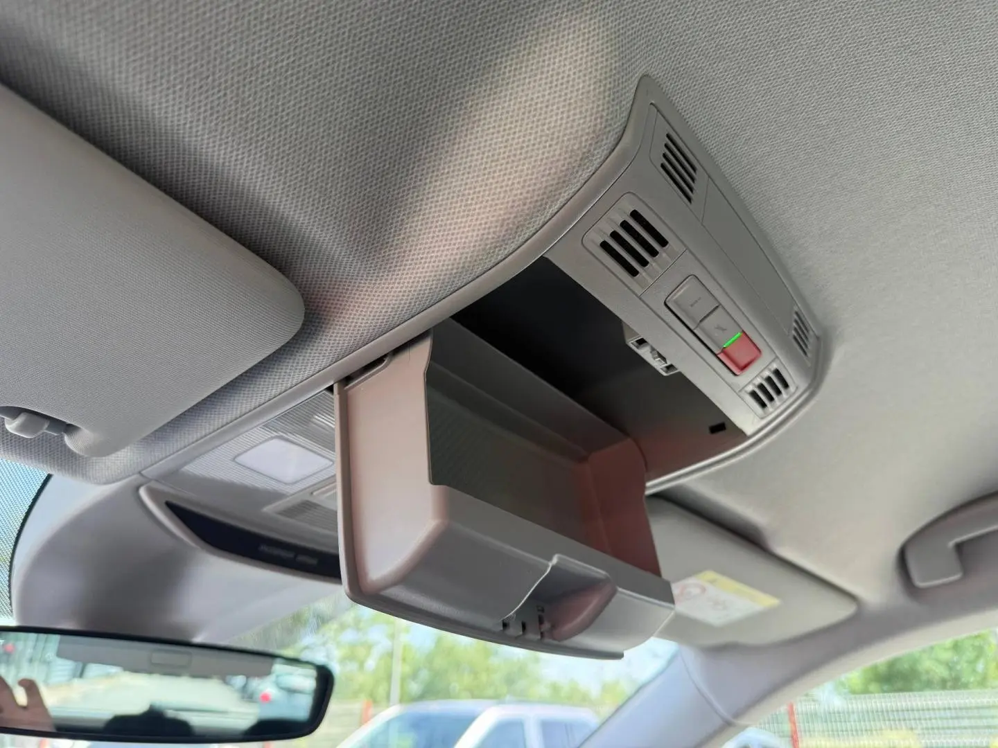 Boîte à lunettes ouverte vue de l'intérieur du toit d'un Skoda Kamiq 2025, avec plafonnier et commandes intégrées.