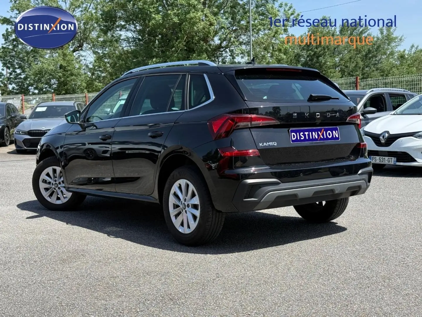 Vue 3/4 arrière droite d’un Skoda Kamiq 2025 noir Magic nacré avec jantes argentées sur parking extérieur.