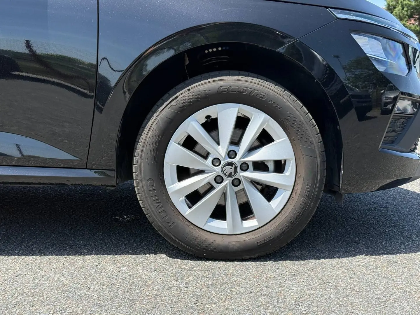 Gros plan sur la roue avant droite d’un Skoda Kamiq noir Magic nacré, mettant en valeur la jante et le pneu.