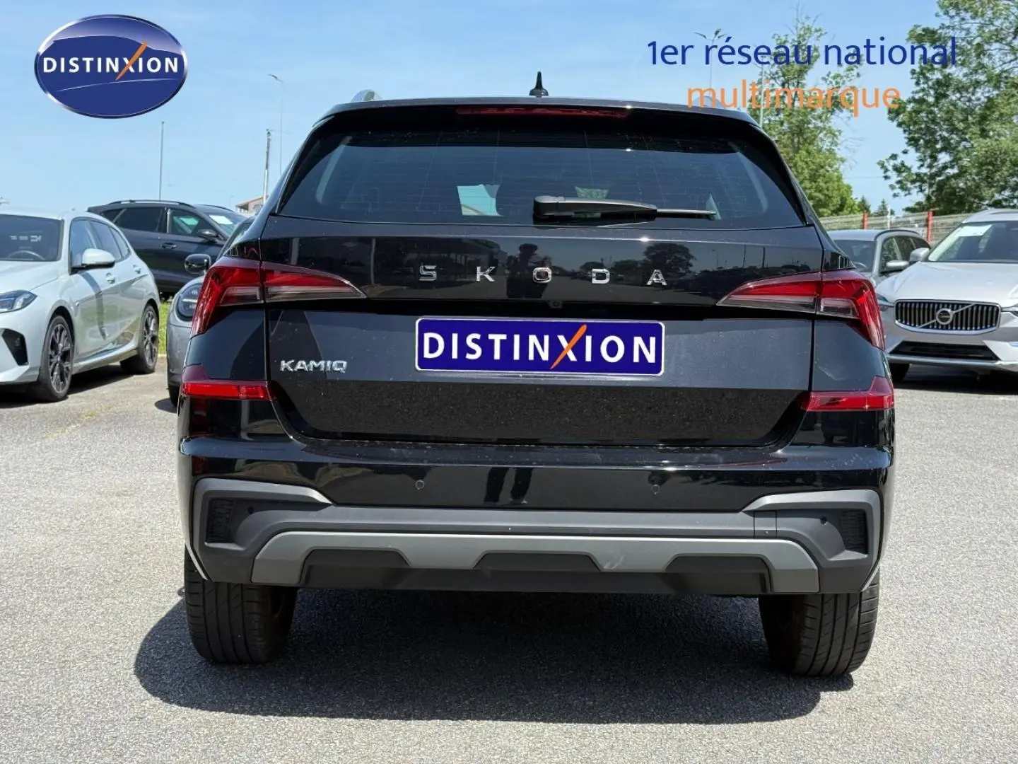 Vue arrière d'un Skoda Kamiq noir Magic nacré 2025 avec logo et plaque Distinxion visible en extérieur.
