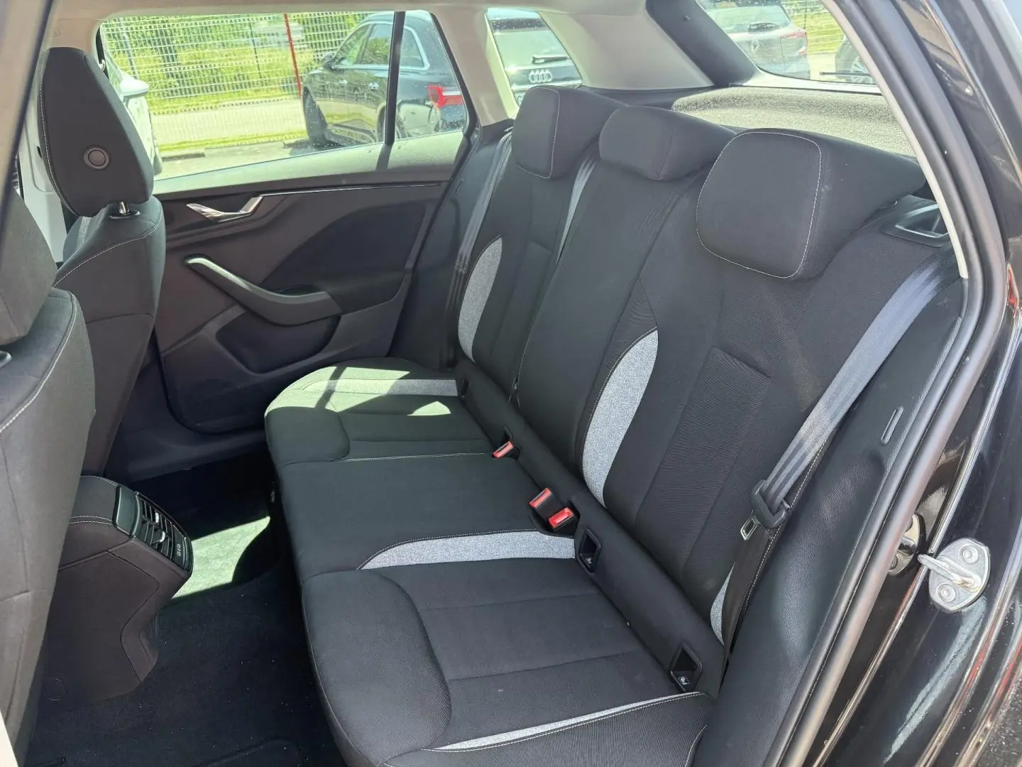 Vue intérieure sur la banquette arrière droite du Skoda Kamiq noir Magic nacré avec sièges tissu bicolores gris et noir.
