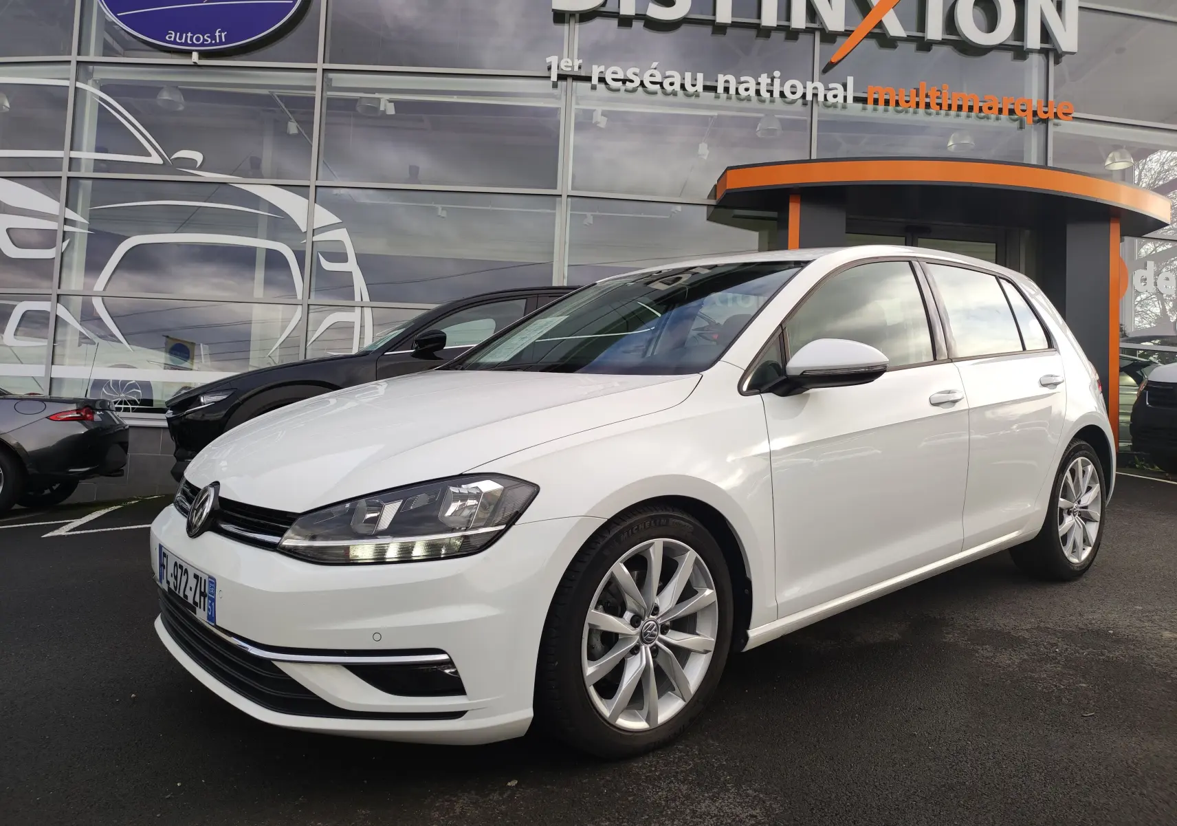 Volkswagen Golf 1.5 TSI EVO blanche vue 3/4 avant droit, avec jantes alliage et feux LED allumés.