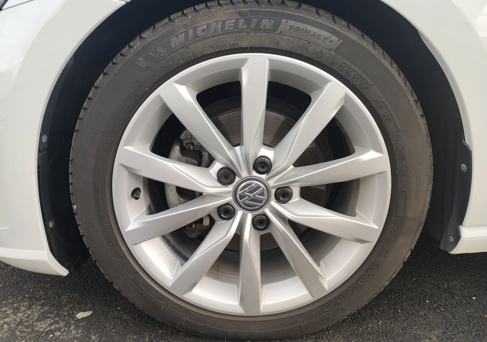 Gros plan sur la roue avant droite d’une Volkswagen Golf blanche 1.5 TSI EVO 2019 avec jante alliage et pneu Michelin.