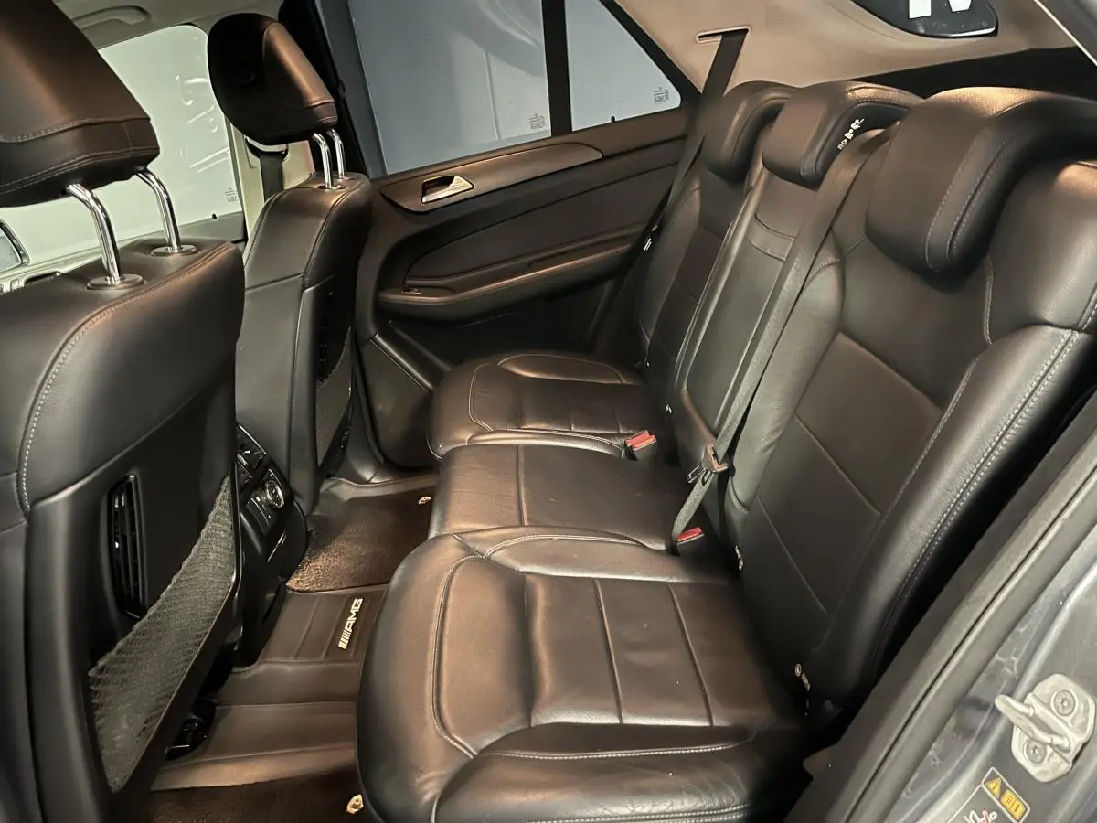 Vue intérieure côté droit des sièges arrière en cuir noir du Mercedes GLE 400 Fascination 2018 avec tapis AMG.