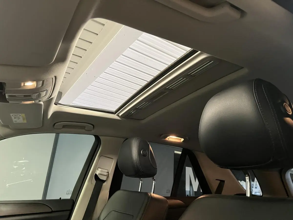 Vue intérieure du toit ouvrant vitré et des sièges avant en cuir noir du Mercedes GLE 400 Fascination 2018