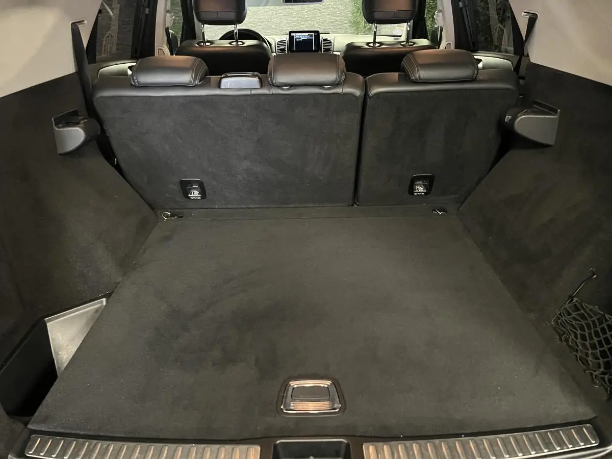 Coffre spacieux du Mercedes GLE 400 gris, vue arrière avec banquette arrière en cuir noir et tablette centrale visible.