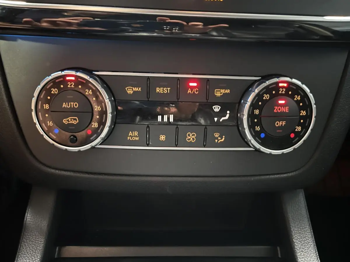 Panneau de commande de climatisation automatique bi-zone du Mercedes GLE 400 gris, avec réglages et voyants lumineux rouges.
