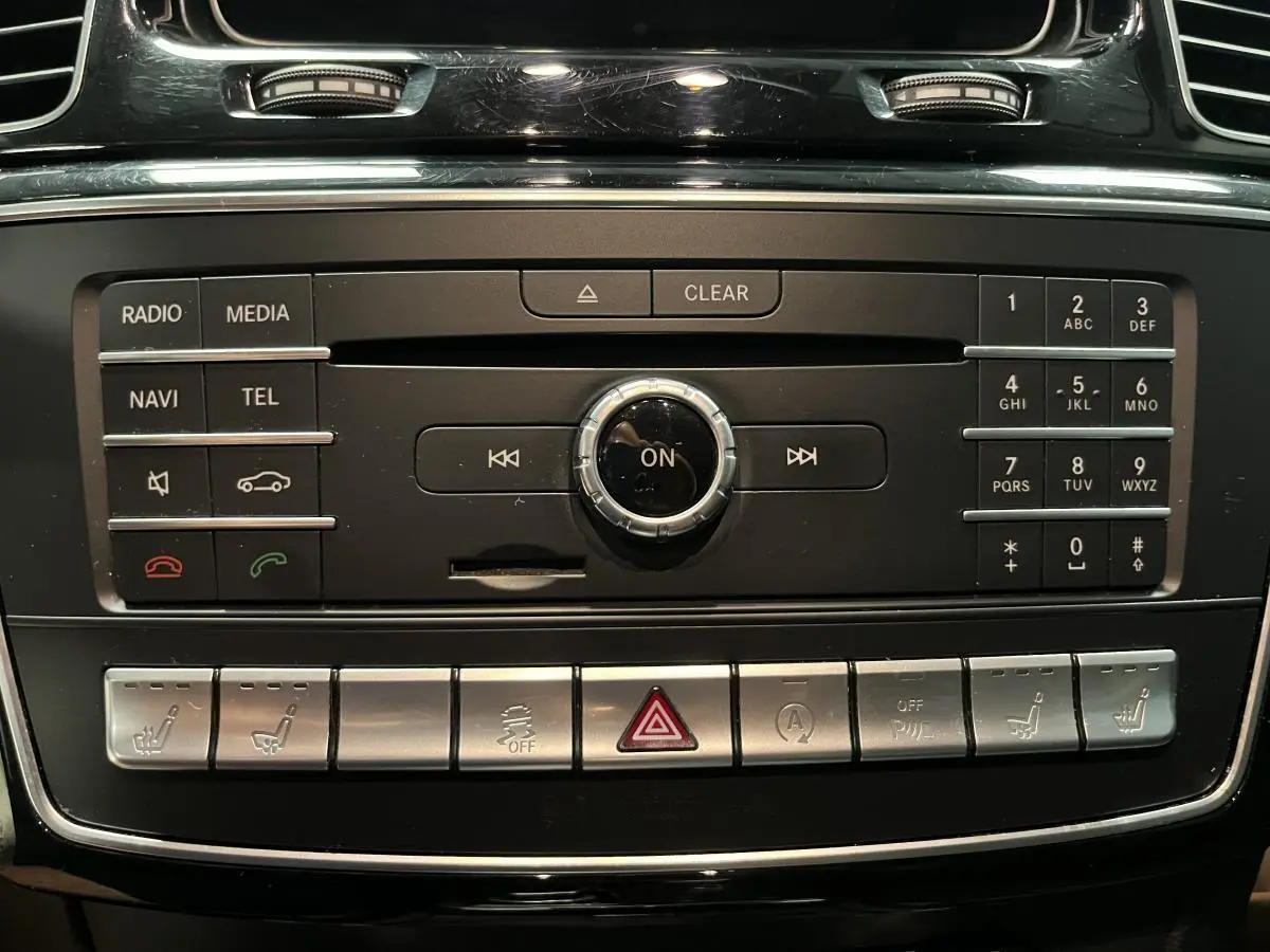 Panneau de commande central noir et argenté du Mercedes GLE 400 Fascination 2018 avec boutons multifonctions et commandes de sièges chauffants.