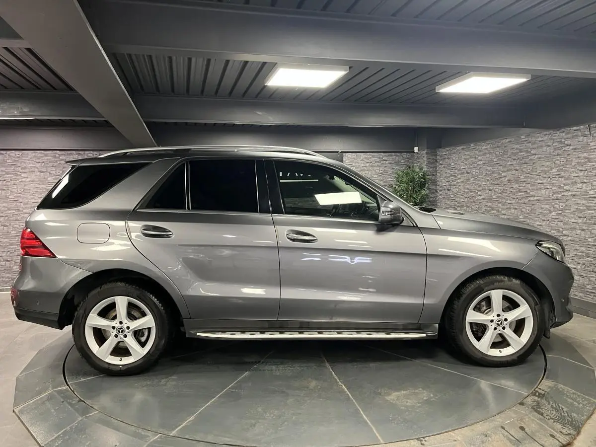 Profil côté droit du Mercedes GLE 400 gris métallisé avec jantes alliage 19 pouces dans un garage fermé.