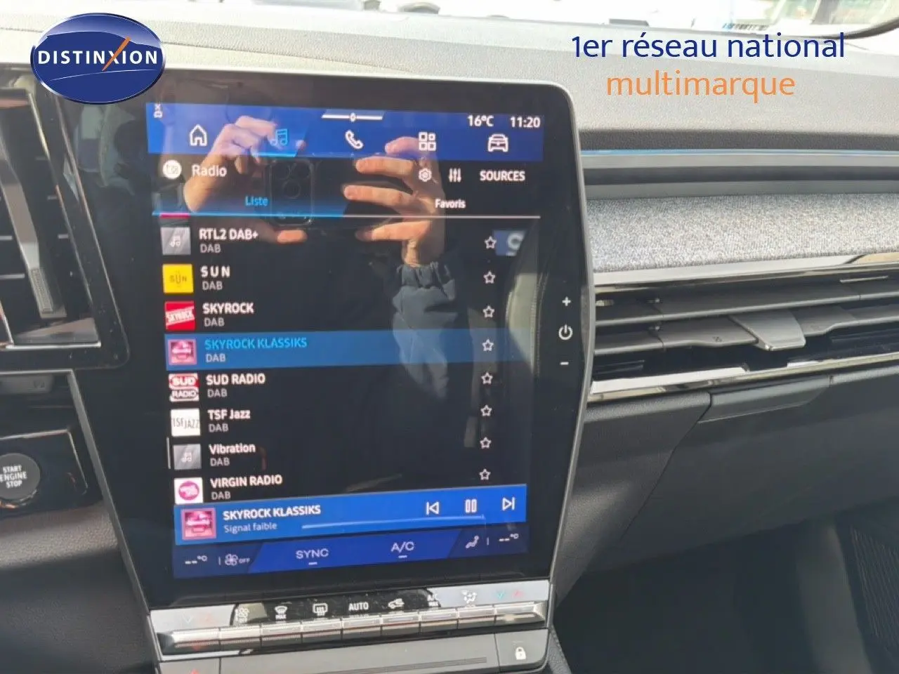 Écran tactile central du tableau de bord d'une Renault Espace noire, affichant les stations radio numériques.