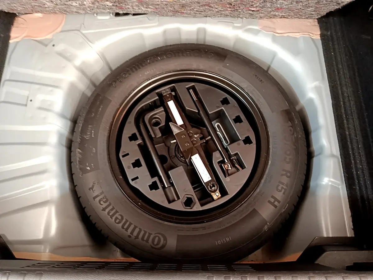 Roue de secours noire avec outils intégrés dans le coffre gris clair d'une Renault Clio Business TCe 100 2020.