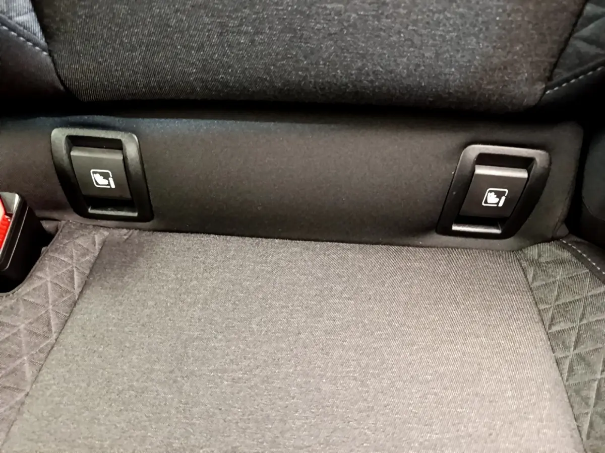 Gros plan sur la banquette arrière grise de la Renault Clio Business TCe 100, montrant les commandes de rabattement des sièges.