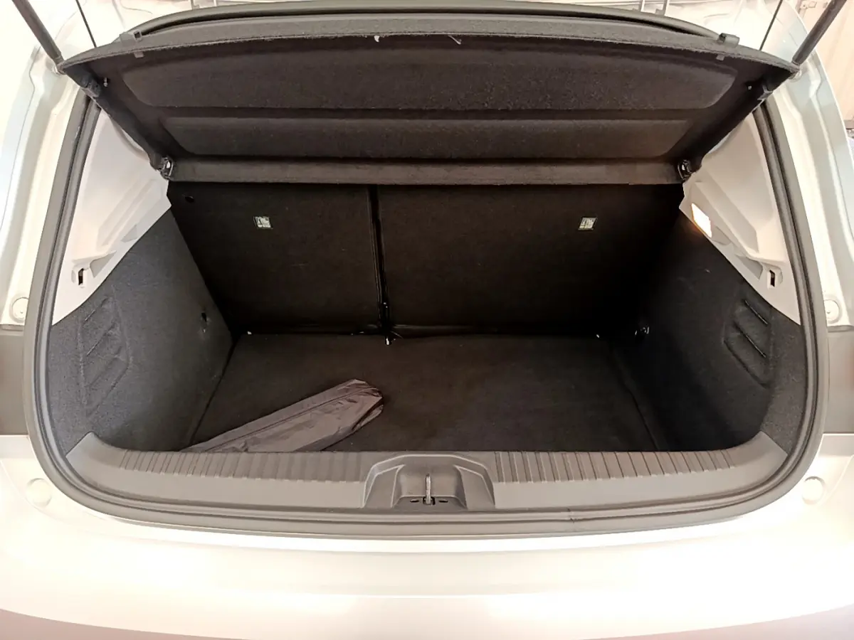 Coffre ouvert vu de l'arrière d'une Renault Clio Business TCe 100 gris clair, montrant un espace de chargement propre et spacieux.