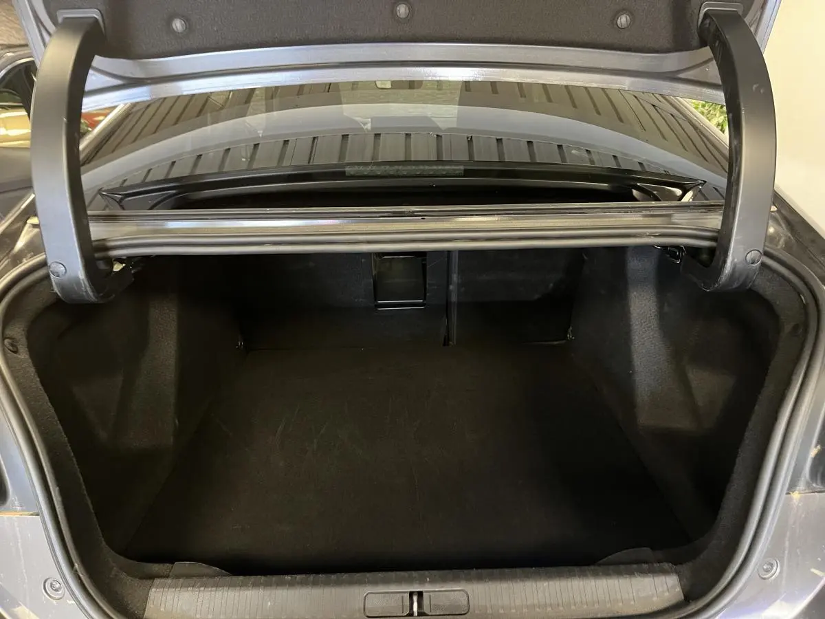Coffre ouvert d'une Citroën C4 X 2024 gris, vue arrière montrant l'espace de chargement vide.
