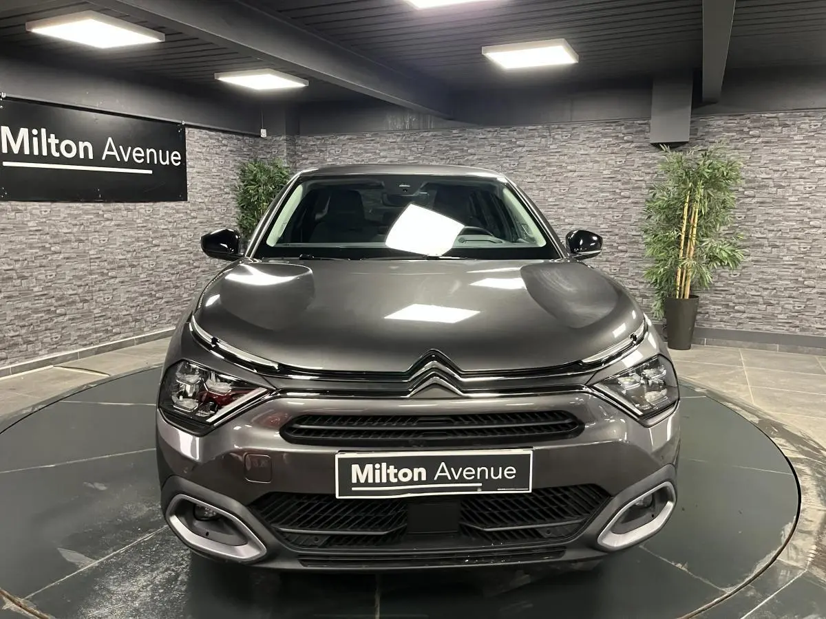 Vue frontale d'une Citroën C4 X gris métallisé 2024 avec signature lumineuse en V et calandre noire brillante.