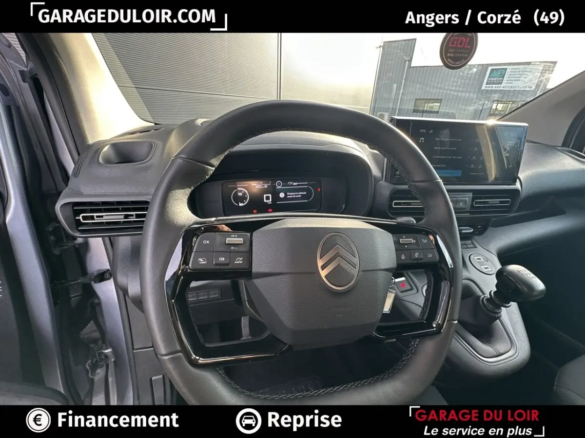 Vue intérieure centrée sur le volant cuir multifonctions et le combiné numérique du Citroën Berlingo gris clair 2024.