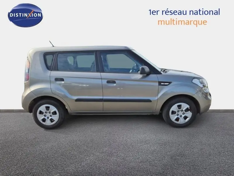 Vue de profil côté gauche d'une KIA SOUL 2010 couleur gris métallisé avec poignées et protections latérales noires.