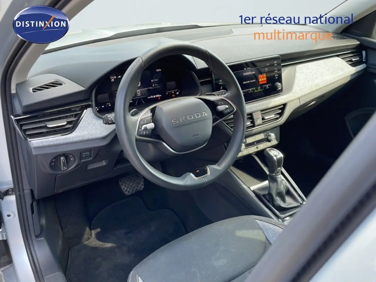 Vue intérieure côté conducteur du Skoda Kamiq gris argent, avec volant multifonction et tableau de bord digital.