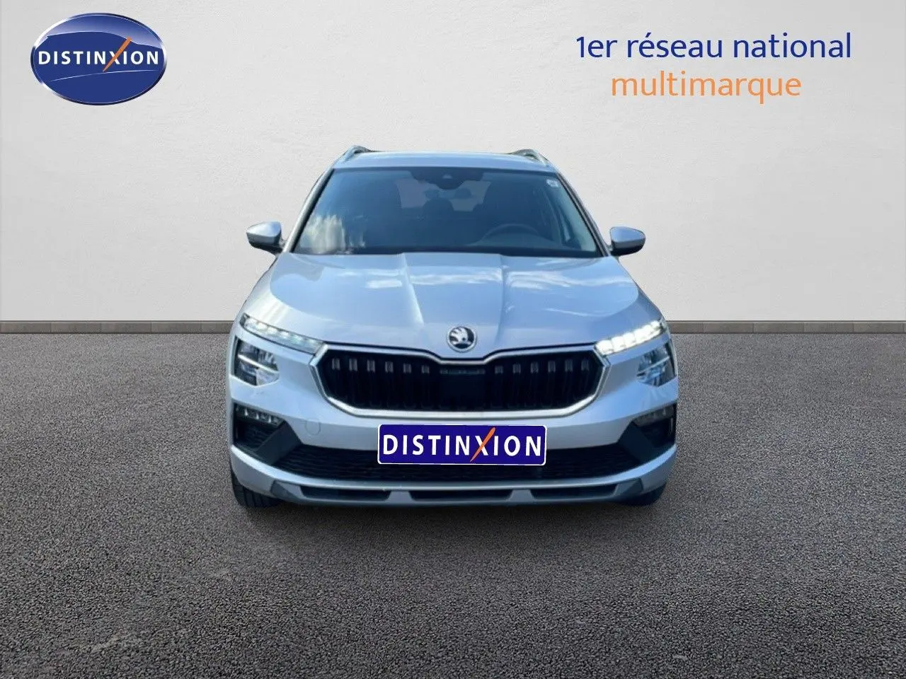 Vue frontale d'un Skoda Kamiq gris argent métal 2025 avec calandre noire et feux LED allumés.