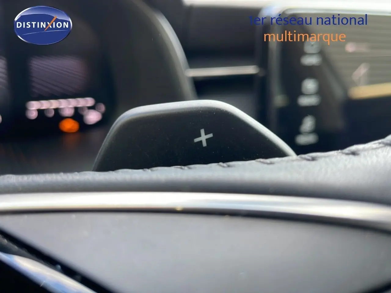 Gros plan sur la palette de changement de vitesse + du Skoda Kamiq 2025, intérieur cuir noir avec tableau de bord flou.