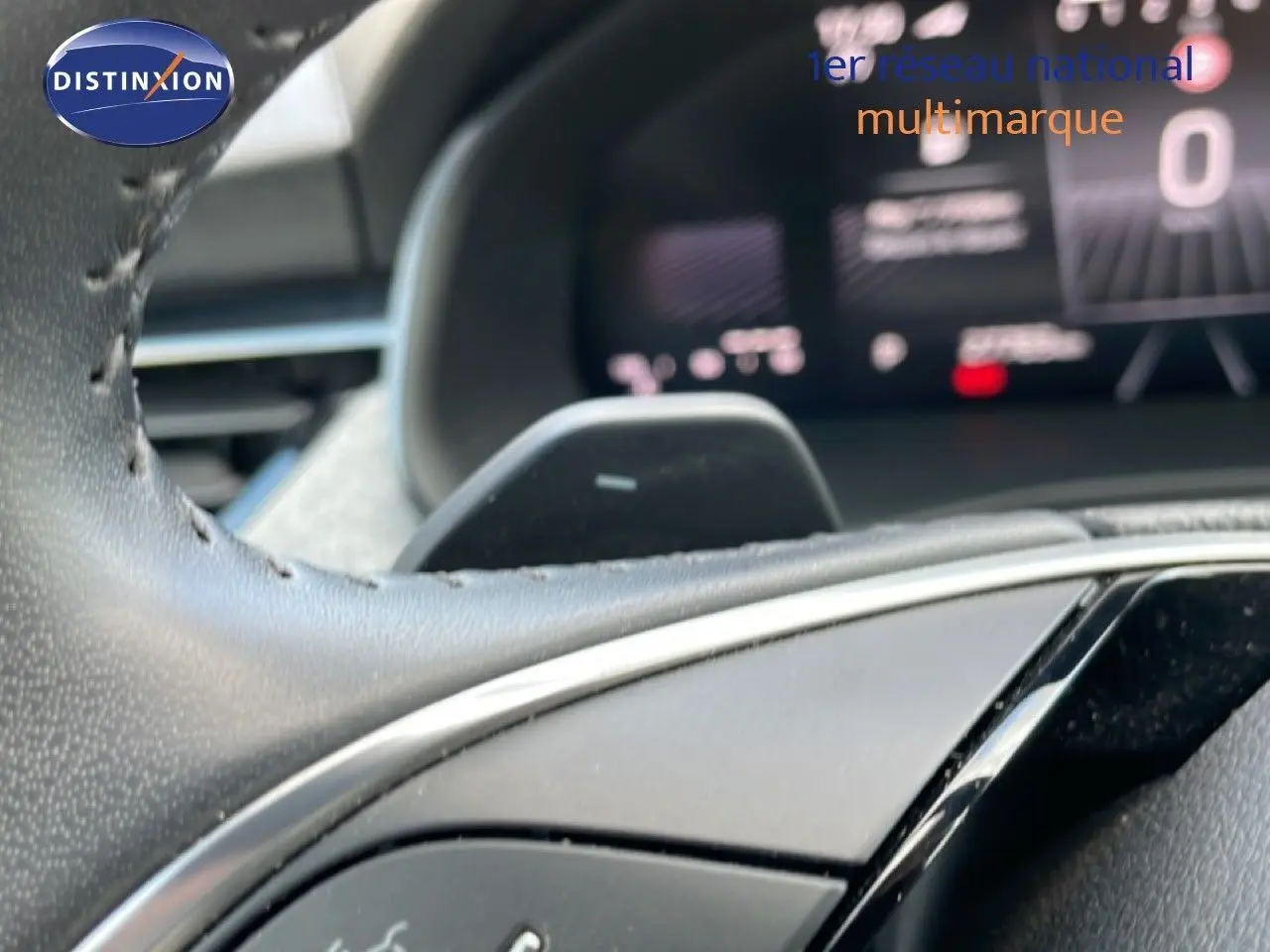 Gros plan sur le volant cuir noir du Skoda Kamiq 2025 avec commandes intégrées et tableau de bord numérique flou en arrière-plan.