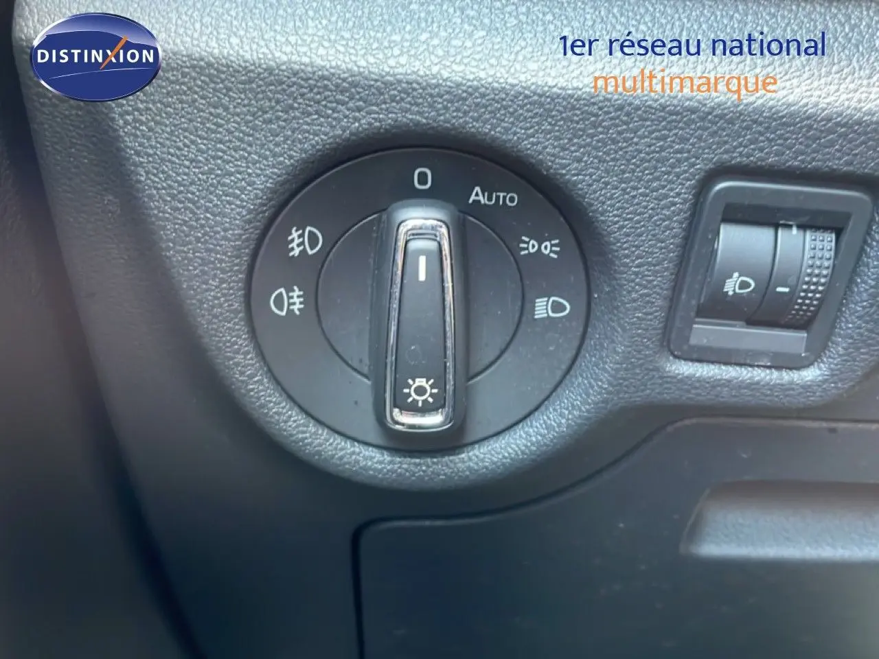 Gros plan sur le bouton de commande des phares dans l’habitacle d’un Skoda Kamiq gris argent 2025.