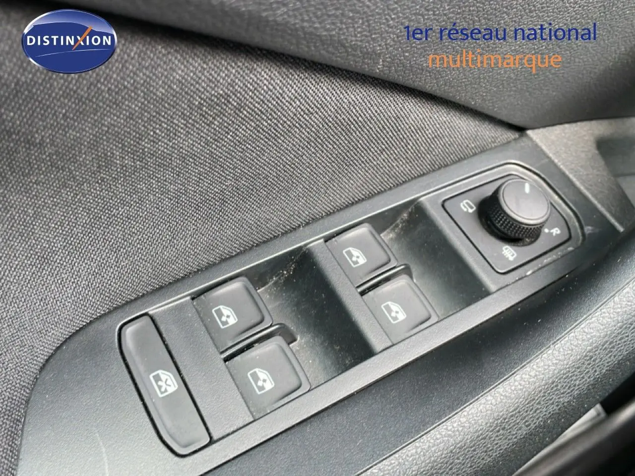 Gros plan sur les commandes de lève-vitres et réglage des rétroviseurs côté conducteur d’un Skoda Kamiq gris argent 2025.