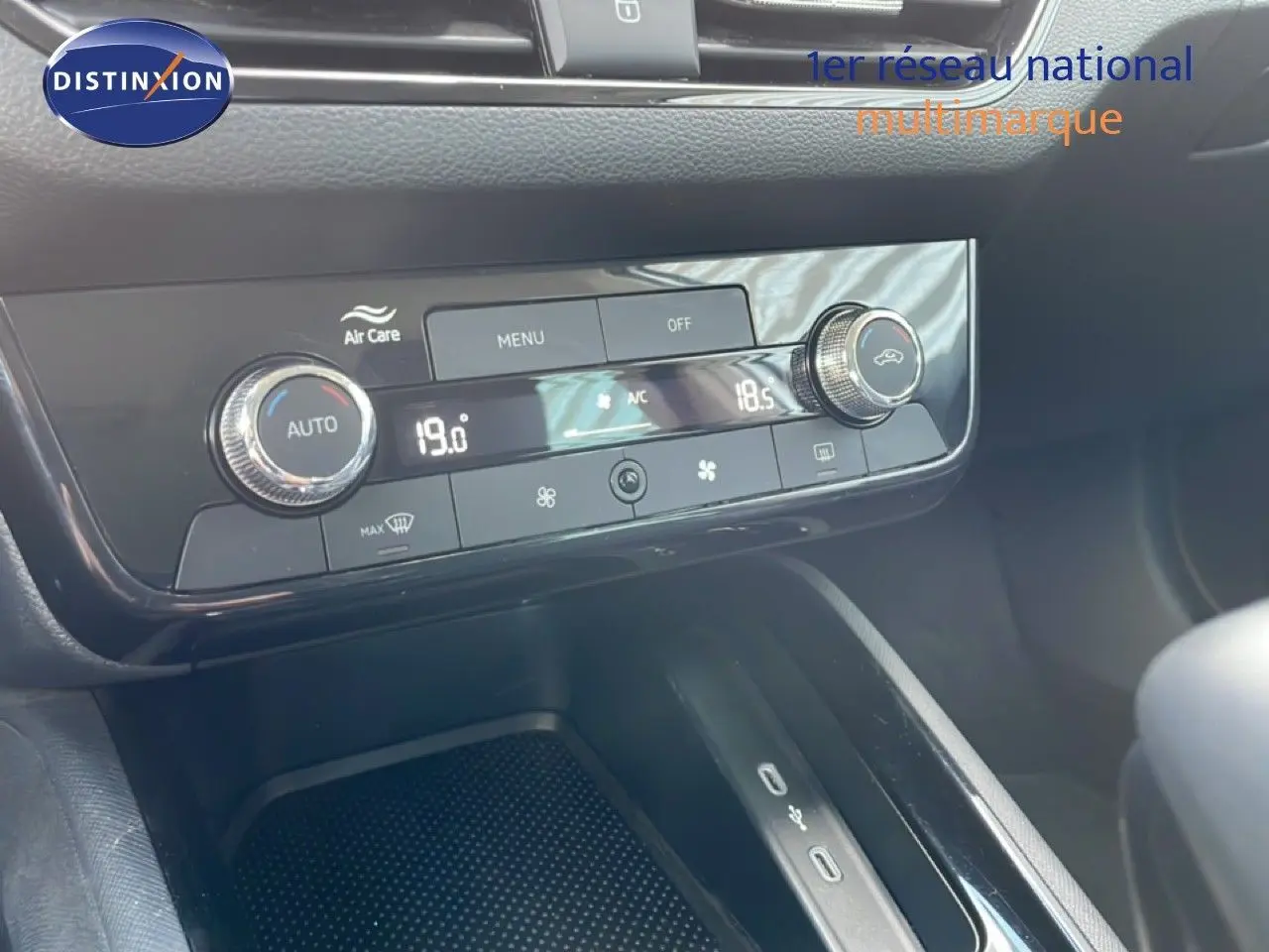 Gros plan sur la console centrale du Skoda Kamiq gris argent, mettant en valeur la climatisation automatique et les ports USB.