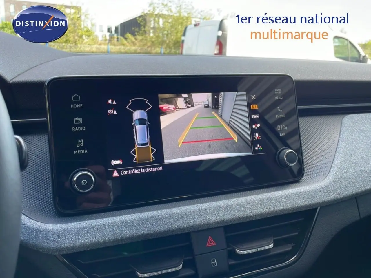 Écran central du Skoda Kamiq gris argent 2025 montrant la caméra de recul avec guidage de trajectoire coloré.